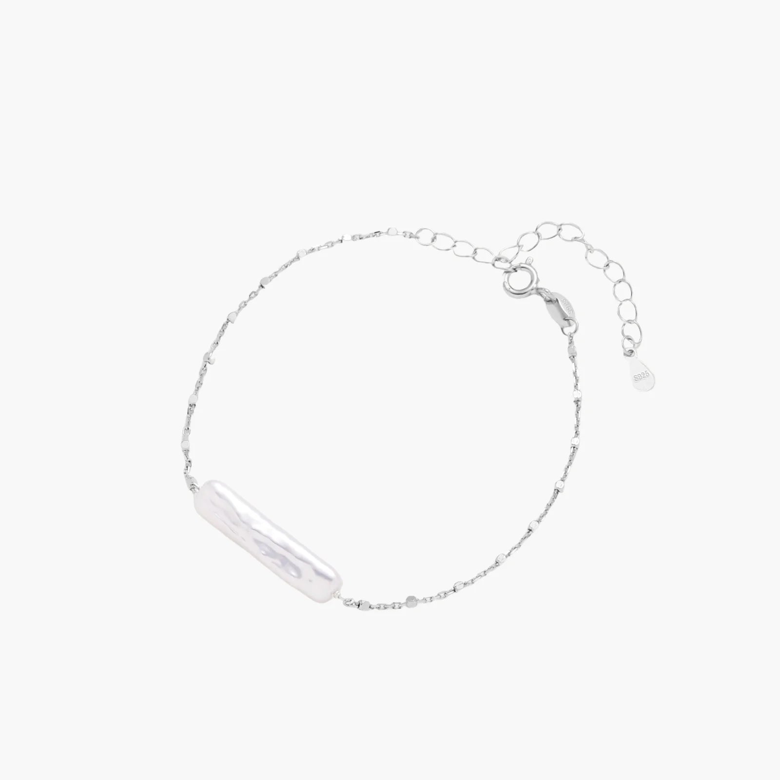 Minimalist bracelet with iridescent baroque pearl on rhodium-plated sterling silver chain against cream background