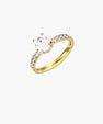 Gold-plated solitaire ring with oval zirconia center stone and pavé band on cream background