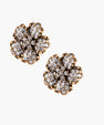 Gold-plated floral stud earrings with geometric zirconia crystals arranged in five-petal design on cream background